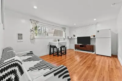a living room with a bed and a kitchen with a table at Cozy 2BR Suite Near White Rock Beach in Surrey