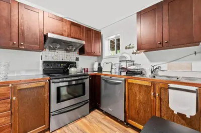 a kitchen with wooden cabinets and stainless steel appliances at Cozy 2BR Suite Near White Rock Beach in Surrey