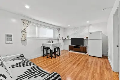 a white living room with a couch and a table at Cozy 2BR Suite Near White Rock Beach in Surrey
