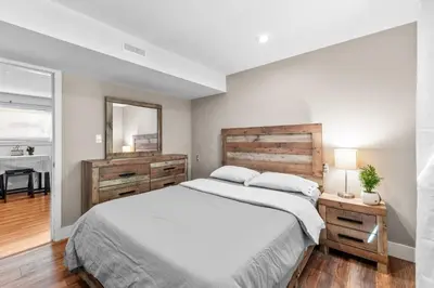 a bedroom with a large bed and a mirror at Cozy 2BR Suite Near White Rock Beach in Surrey