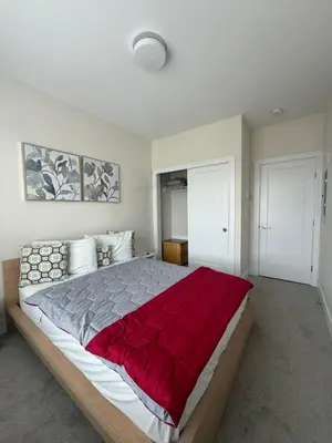 a bedroom with a large bed with a red blanket at Ventura in Downtown in Abbotsford