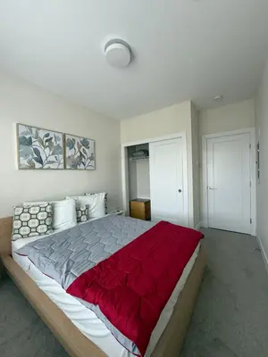 a bedroom with a large bed with a red blanket at Ventura in Downtown in Abbotsford