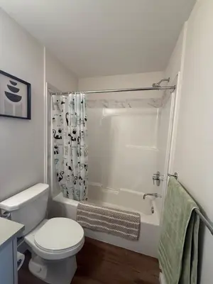 a white bathroom with a toilet and a shower at Ventura in Downtown in Abbotsford