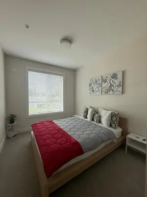 a bedroom with a large bed with a red blanket at Ventura in Downtown in Abbotsford