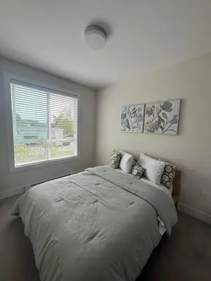 a bedroom with a large bed and a window at Ventura in Downtown in Abbotsford