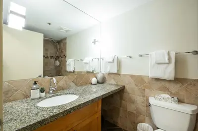 a bathroom with a sink and a toilet and a mirror at Glacier Lodge 216 by Outpost Whistler in Whistler