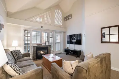 a living room with two couches and a fireplace at Glacier Lodge 309 by Outpost Whistler in Whistler