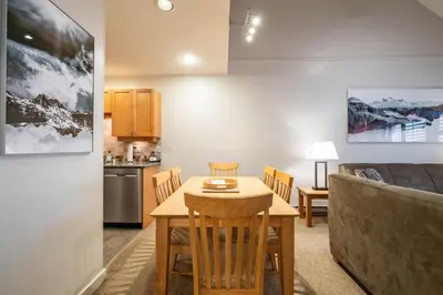 a kitchen and dining room with a table and a couch at Glacier Lodge 309 by Outpost Whistler in Whistler