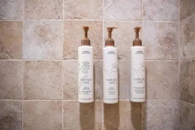 a trio of three bottles sitting on a tile wall at Glacier Lodge 309 by Outpost Whistler in Whistler