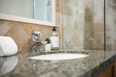 a bathroom counter with a sink and a bottle of soap at Glacier Lodge 309 by Outpost Whistler in Whistler