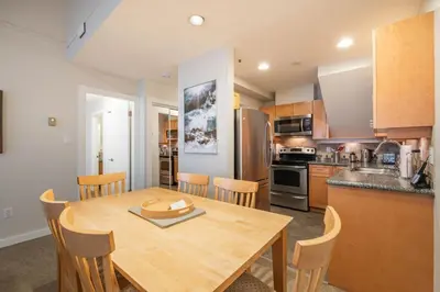 a kitchen and dining room with a wooden table and chairs at Glacier Lodge 309 by Outpost Whistler in Whistler