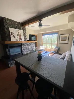 a living room with a table and a fireplace at Sable Ridge Retreat in Radium Hot Springs