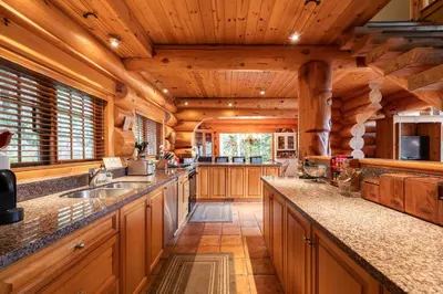 a kitchen with wooden cabinets and a large counter top at Heron Chalet by Outpost Whistler in Whistler