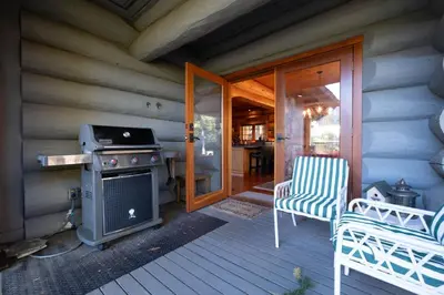 a porch of a house with a stove and chairs at Heron Chalet by Outpost Whistler in Whistler