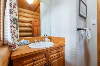 a bathroom with a sink and a mirror at Heron Chalet by Outpost Whistler in Whistler