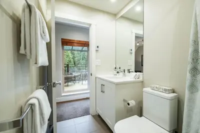 a white bathroom with a toilet and a sink at Lake Placid Lodge 18 by Outpost Whistler in Whistler