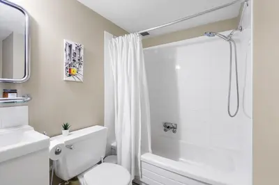 a white bathroom with a toilet and a shower at Cozy Home in Downtown Minutes from Seawall in Vancouver