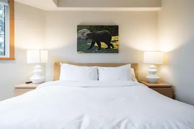 a bedroom with a white bed and two lamps at Le Chamois 508 by Outpost Whistler in Whistler