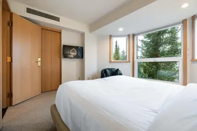 a bedroom with a large white bed and a window at Le Chamois 508 by Outpost Whistler in Whistler