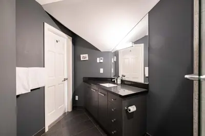 a black bathroom with a sink and a mirror at Lynx 204 by Outpost Whistler in Whistler
