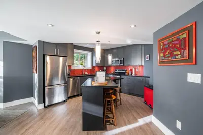 a kitchen with stainless steel appliances and a black island at Lynx 204 by Outpost Whistler in Whistler