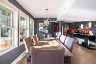 a kitchen and dining room with a wooden table and chairs at Lynx 204 by Outpost Whistler in Whistler