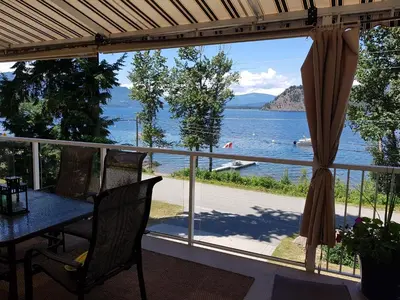 a balcony with a table and a view of the water at West facing Waterfront Retreat with private beach, dock access & private buoy in Blind Bay