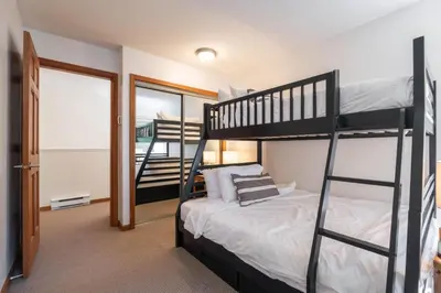 a bedroom with two bunk beds and a staircase at Northstar 51 by Outpost Whistler in Whistler