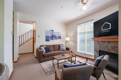 a living room with a couch and a fireplace at Northstar 51 by Outpost Whistler in Whistler