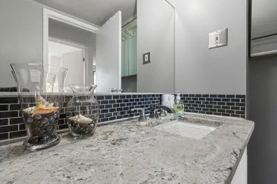 a bathroom counter with a sink and a mirror at Suite near Downtown, BMO, Stampede, Free Parking in Calgary