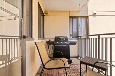 an apartment balcony with a stove and a chair at Modern 2 bedroom next to Stampede, 17th w Parking in Calgary