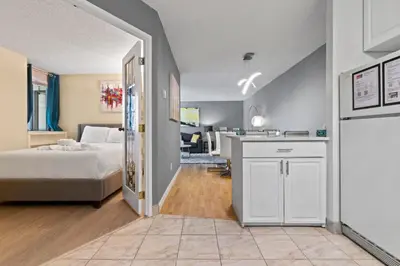 a bedroom with a bed and a kitchen in a room at Modern 2 bedroom next to Stampede, 17th w Parking in Calgary