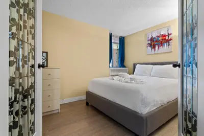 a bedroom with a white bed and a window at Modern 2 bedroom next to Stampede, 17th w Parking in Calgary