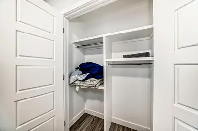 a walk in closet with a white door at 2 Beds, 1 bath Walkout Basement in Calgary