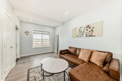 a living room with a couch and a table at 2 Beds, 1 bath Walkout Basement in Calgary