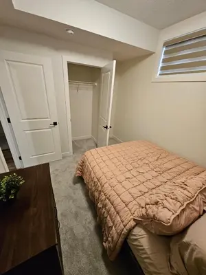 a bedroom with a bed and a closet at Emeka & Comfort in Calgary