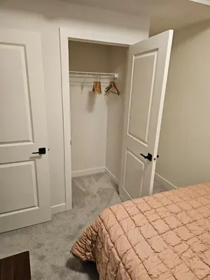 a bedroom with a bed and a closet at Emeka & Comfort in Calgary