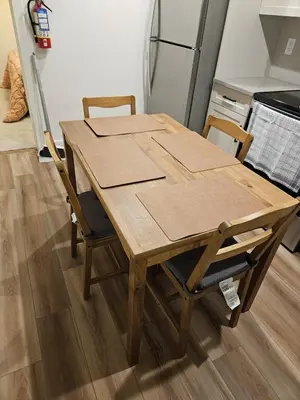 a kitchen table with two chairs and a refrigerator at Emeka & Comfort in Calgary