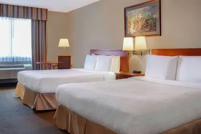 a hotel room with two beds and a window at Days Inn by Wyndham Whitecourt in Whitecourt