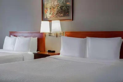 two beds with white pillows in a hotel room at Days Inn by Wyndham Whitecourt in Whitecourt
