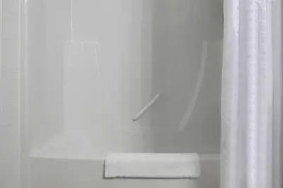 a bathroom with a shower curtain and a towel at Days Inn by Wyndham Whitecourt in Whitecourt