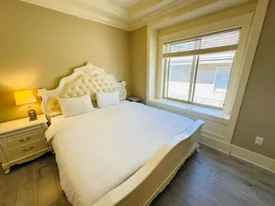 a bedroom with a large bed and a window at Vancouver Airport Love Home Inn in Richmond