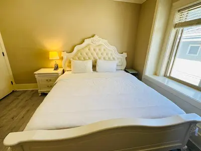 a bedroom with a large white bed with a window at Vancouver Airport Love Home Inn in Richmond
