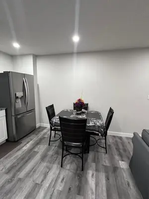 a dining room with a table and a refrigerator at Elegant Cozy Private Apartment in Calgary