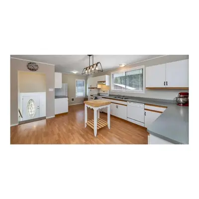 an open kitchen with white cabinets and a table at Youbou Lakefront Getaway Relax And Unwind in Youbou