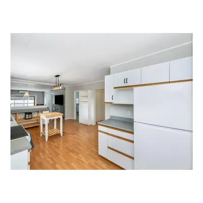 a kitchen with white cabinets and a dining room at Youbou Lakefront Getaway Relax And Unwind in Youbou
