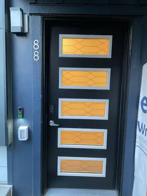 a black door with orange accents on a building at Cozy & Stylish AC Suite Near YYC Airport in Calgary
