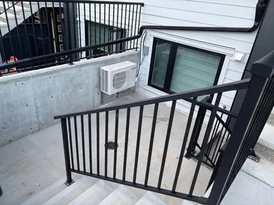 a balcony with a air conditioner sitting on a porch at Cozy & Stylish AC Suite Near YYC Airport in Calgary