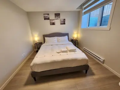 a bedroom with a bed with two books on it at Cozy & Stylish AC Suite Near YYC Airport in Calgary