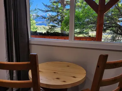 a wooden table and two chairs in front of a window at Alpenrose 100 King bed Hottub Mountains Views in Golden